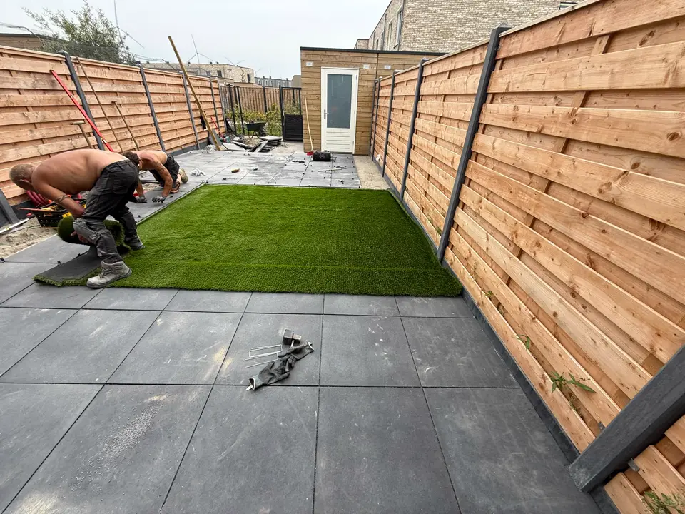 Kunstgras wordt uitgerold naast het nieuwe terras